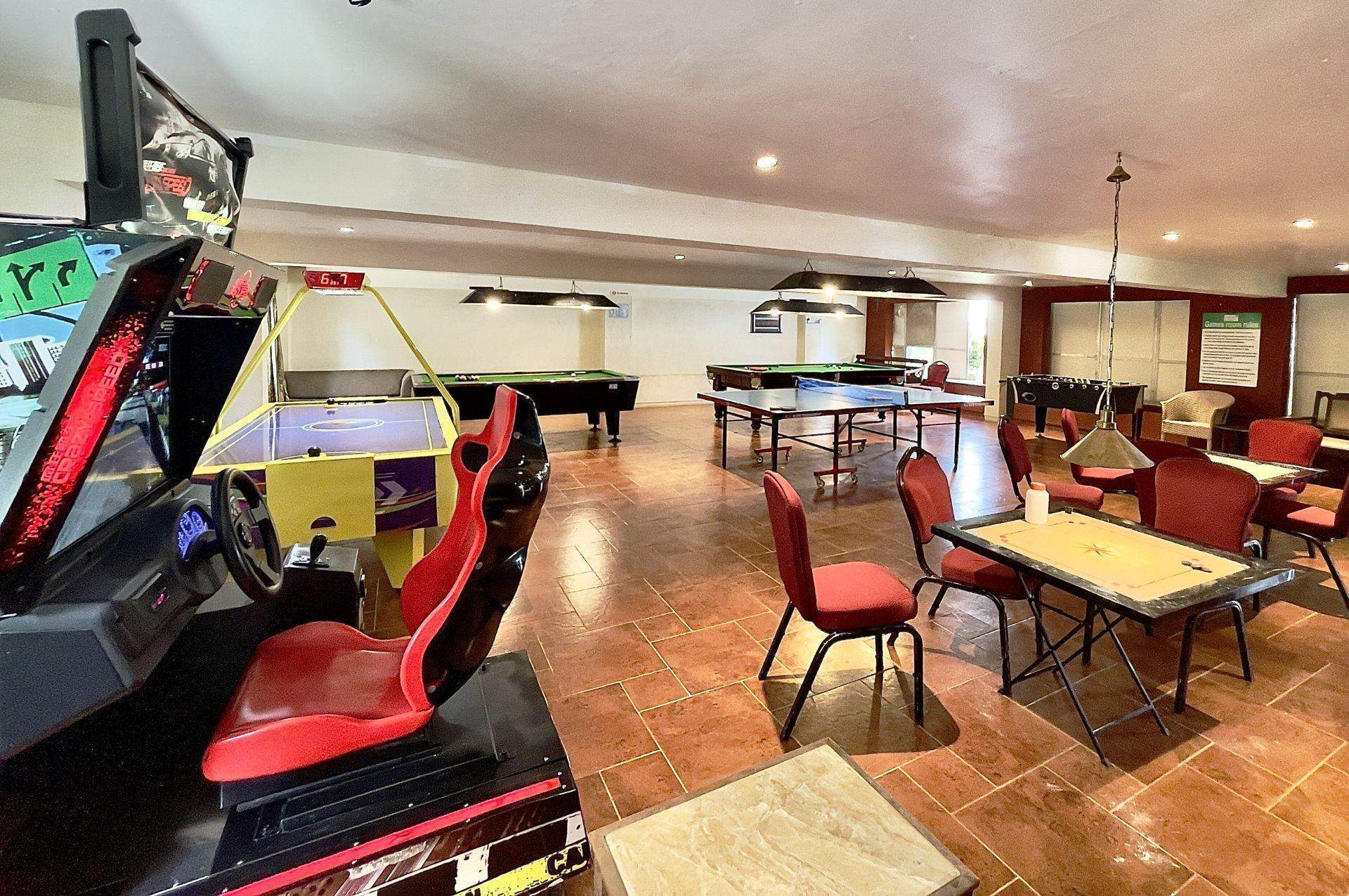 An indoor playroom at Ramsukh Resort, equipped with slides, toys, and a wooden floor, providing a fun space for children.